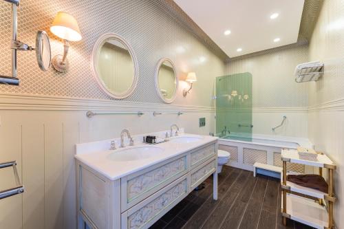 a bathroom with a sink and a tub and mirror at RuinAdalia Hotel in Antalya