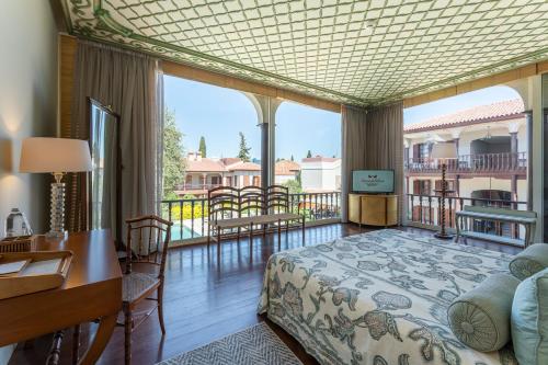 a bedroom with a bed and a desk and a balcony at RuinAdalia Hotel in Antalya