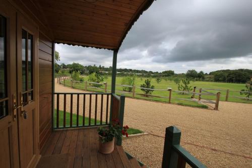 a porch of a house with a view of a field at Le Grande Roulotte in Hassocks