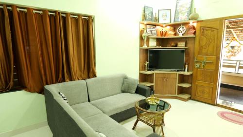 a living room with a couch and a tv at Atharvam Resort in Cherai Beach