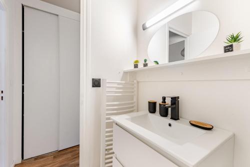 a white bathroom with a sink and a mirror at Charmant Studio Cosy - Hyper-Centre D'Elbeuf in Elbeuf