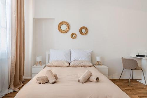 a white bedroom with a large bed with two pillows at Charmant Studio Cosy - Hyper-Centre D'Elbeuf in Elbeuf