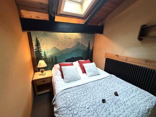 a bedroom with a bed with a painting on the wall at LA POMME DE PIN 1 Appartement avec terrasse in La Bresse