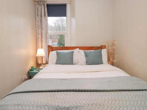 a bedroom with a large bed with a window at The Wonky Nest in Windermere