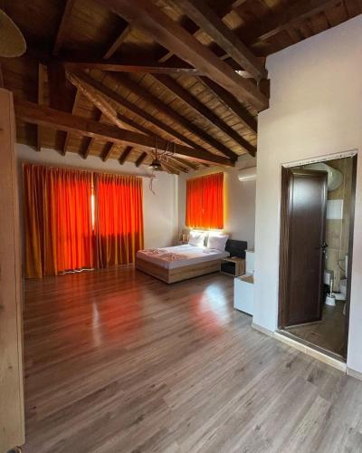 a large room with a bed and red curtains at Studio 8 Arapya in Tsarevo
