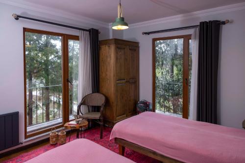ein Schlafzimmer mit einem rosa Bett und zwei Fenstern in der Unterkunft loidevilla in Kemalpasa