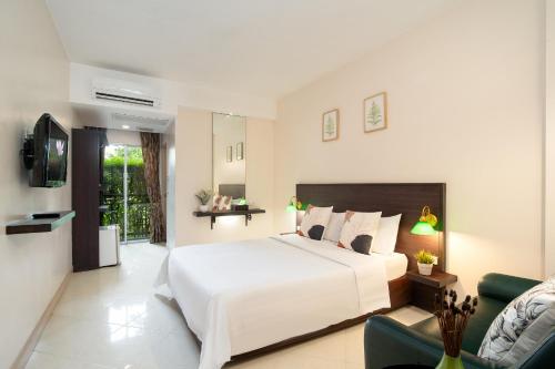 a bedroom with a large white bed and a couch at โรงแรมสินสิริ ปัญญา-รามอินทรา in Bangkok