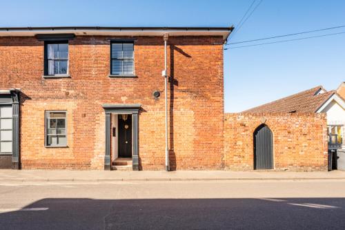 a brick building on the side of a street at The Leiston, 1 Valley Road in Leiston
