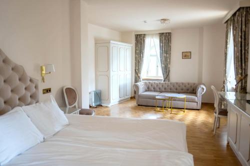 a bedroom with a white bed and a couch at Pałac Popielów w Kurozwękach- pokoje w Pałacu in Kurozwęki