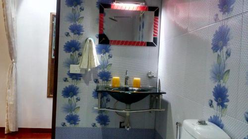a bathroom with a sink with blue flowers on the wall at Marari Umapathi Beach Villa in Mararikulam