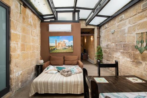 a room with two beds and a table in it at Traditional Maltese 2-Bedroom Home with Private Hot Tub - Steps Away from Valletta in Il-Furjana