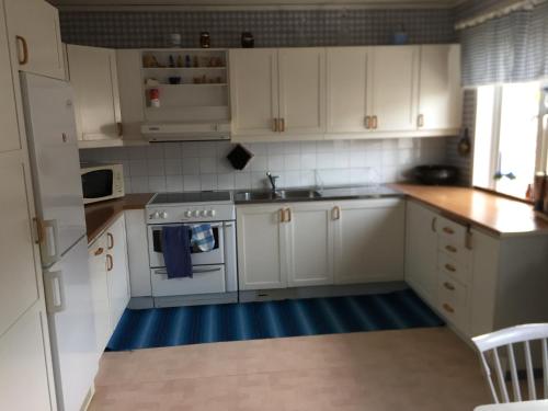 a kitchen with white cabinets and a stove top oven at Lexe 2rok in Gävle