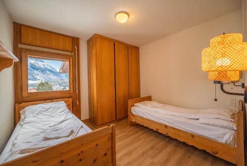 a bedroom with two beds and a window at Chesa Sarvit in Celerina
