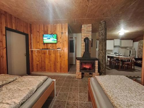 a room with two beds and a fireplace at Levendula Vendégház in Ács