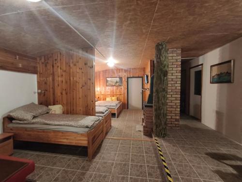 a room with two beds and a brick wall at Levendula Vendégház in Ács