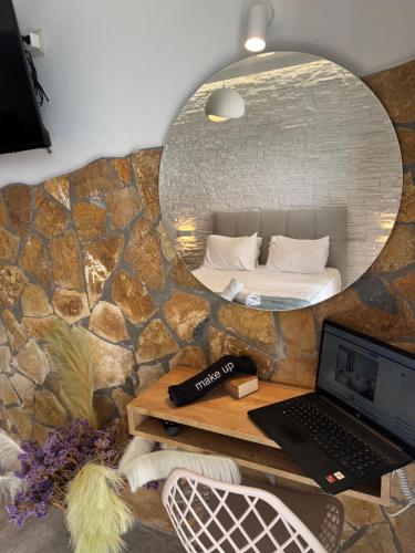 a bedroom with a mirror and a laptop on a table at Vladimiros Apartments in Barbati