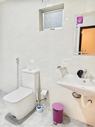 a white bathroom with a toilet and a sink at bluemoonhiriketiya in Dickwella