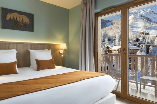 a hotel room with a bed and a balcony at SOWELL HÔTEL L'Alpe Blanche in Vars