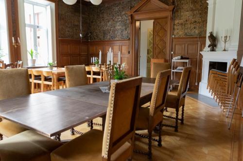 a dining room with a wooden table and chairs at Hellidens Slott in Tidaholm