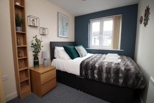 a bedroom with a bed and a window at Alicia's Way by Tŷ SA in Newport