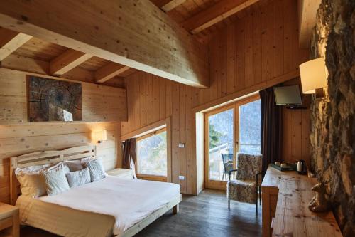 a bedroom with a bed in a wooden room at Chalet Morel 1586 Hotel & Spa in Limone Piemonte