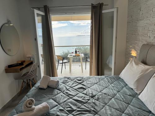 a bedroom with a bed with a view of the ocean at Vladimiros Apartments in Barbati