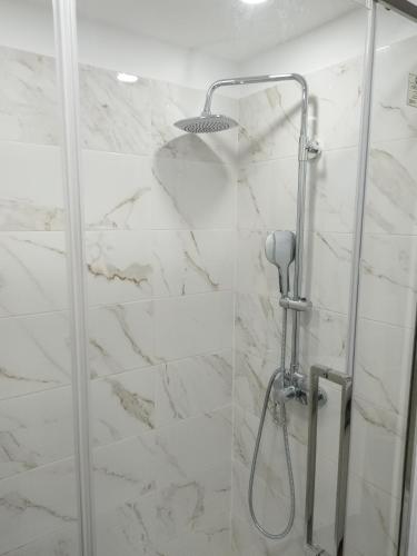 a shower in a bathroom with white marble at charnecas house in Gaula