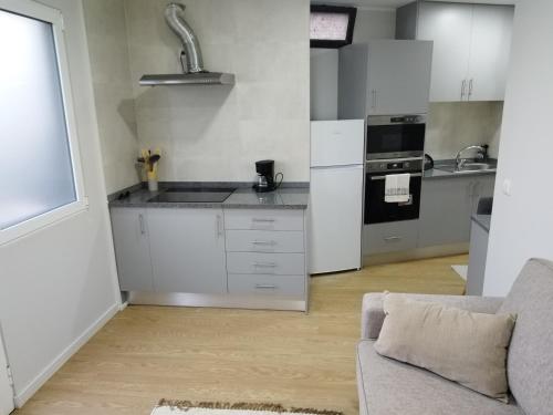 a kitchen with white cabinets and a couch in a room at charnecas house in Gaula