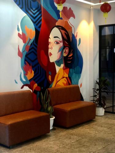 a mural of a woman on a wall in a lobby at Bless Red Hotels in Sintang