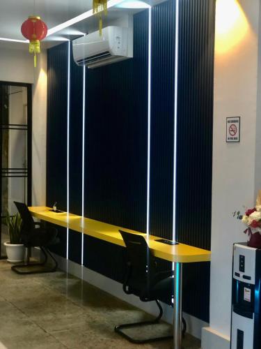 an office cubicle with a yellow desk and chairs at Bless Red Hotels in Sintang