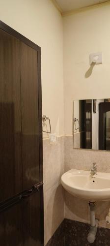 a bathroom with a sink and a mirror at Bonsaiyog in Chapora