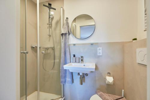 a bathroom with a shower and a sink and a mirror at Haus Antina - App 2 in Borkum