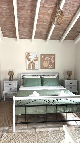 a bedroom with a large bed and two night stands at Loukas house Paxos in Boïkátika
