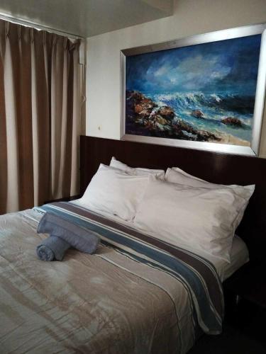 a bed with a stuffed animal sitting on top of it at Coast Residences Roxas Boulevard Manila in Manila