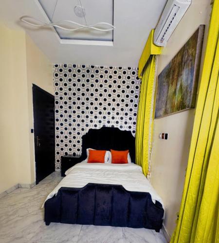 a bedroom with a large bed with yellow curtains at Msb LUXURY HOME in Lekki