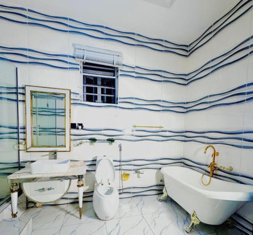 a bathroom with blue and white striped walls and a tub and sink at Msb LUXURY HOME in Lekki