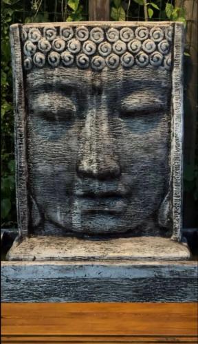 a statue of a face on a wall at Quinta Di Crivelli in Praia do Rosa
