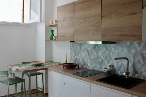 a kitchen with wooden cabinets and a sink at Seaside Apartments - Central Apartments with View - Molfetta in Molfetta