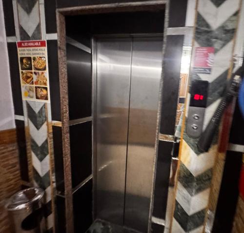 a stainless steel elevator in a room with a wall at mount wood heritage in Dharmsāla