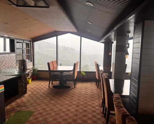 a kitchen and dining room with a table and chairs at mount wood heritage in Dharmsāla