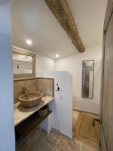 a bathroom with a bowl sink and a mirror at Le Mas Natán in Gordes