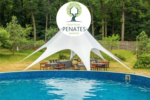 a sign over a swimming pool with a table and chairs at Penates Aparthotel in Koropovo
