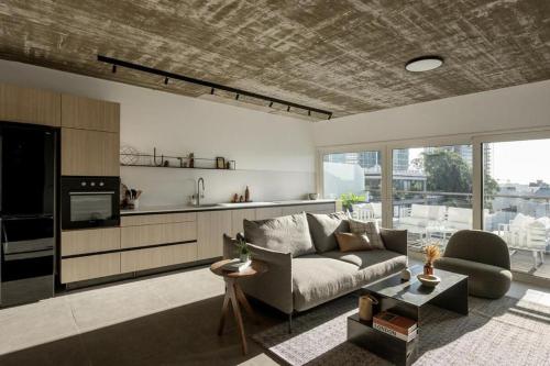 a living room with a couch and a kitchen at Mr Rothschild By TLV2GO in Tel Aviv