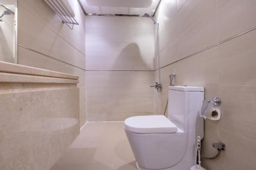a white bathroom with a toilet and a shower at Al Muhaidb Residence Al Takhasossi 2 - Economic in Riyadh