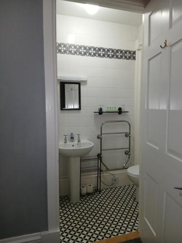 a bathroom with a sink and a toilet at Greenland House B&B in Castletown