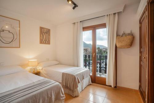 a bedroom with two beds and a large window at Casa "Valldemossa Paradise" in Valldemossa