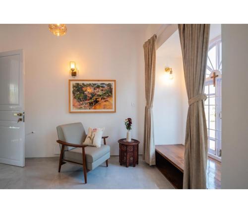 a living room with a chair and a window at Casa De Alegria Goa in Canacona