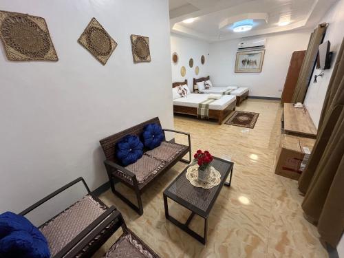 a living room with couches and a table with blue pillows at Luzviminda Farm Homestay in Coron
