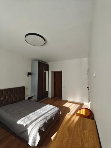 a bedroom with a bed and a wooden floor at Muskatas in Rietavas