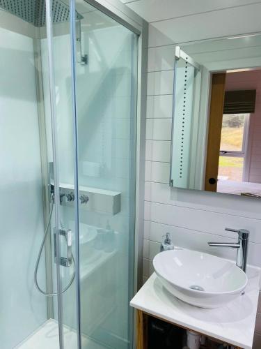 a bathroom with a sink and a glass shower at Dornoch Pods in Dornoch